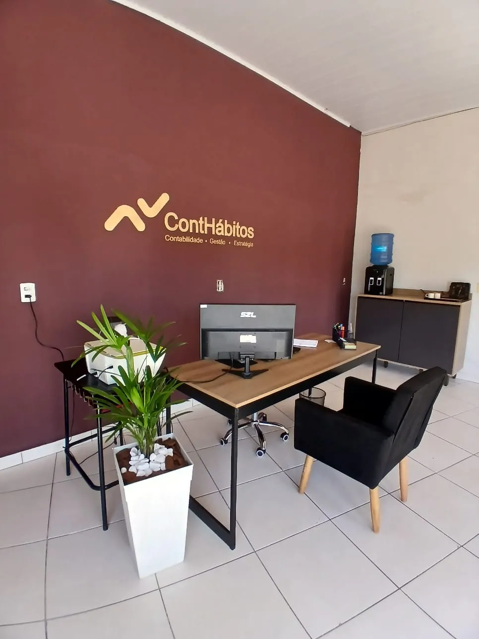 Escritório da ContHábitos, com a logomarca na parede
